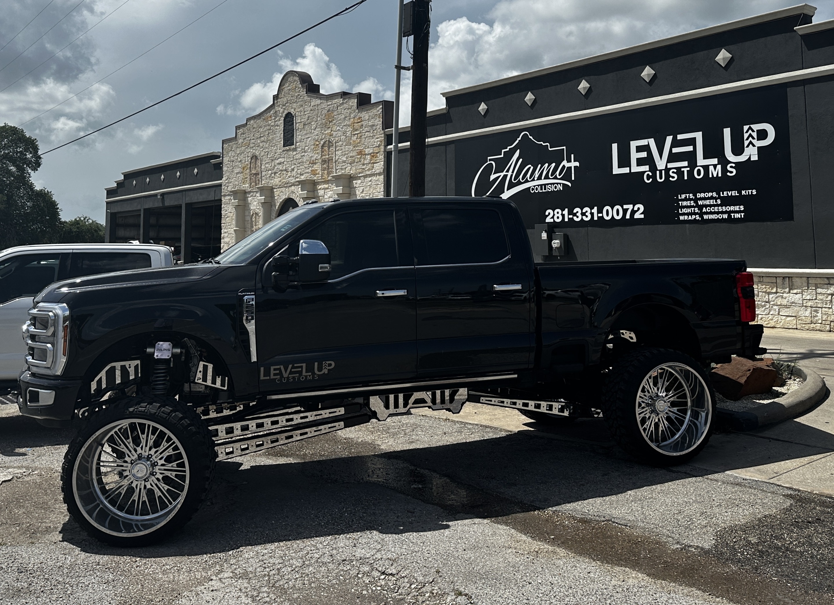 Level Up Customs shop — lifted black Ford F-250 Platinum in front of Alvin TX location