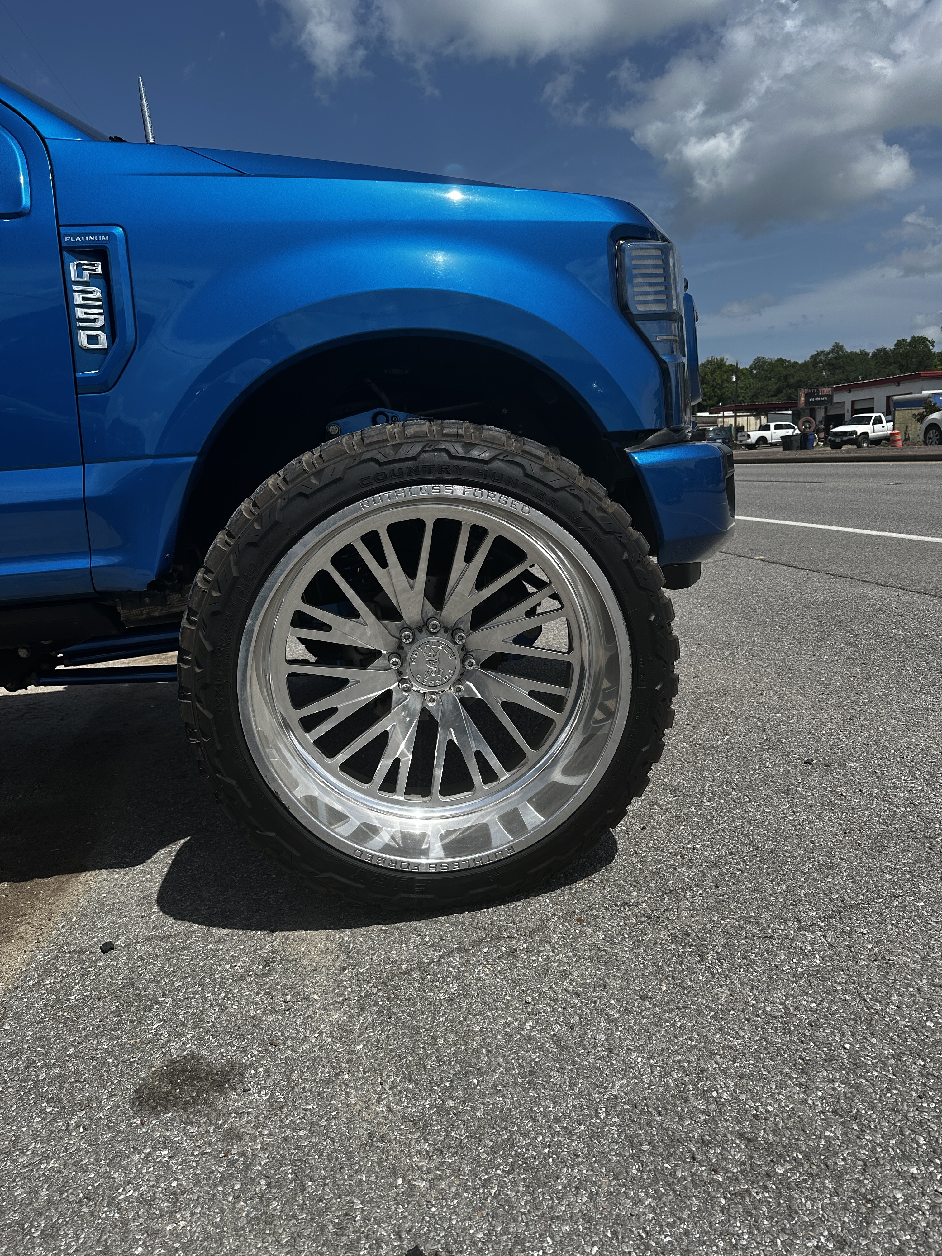 Ruthless Forged wheel close-up on lifted candy blue Ford F-250, Level Up Customs, Alvin TX