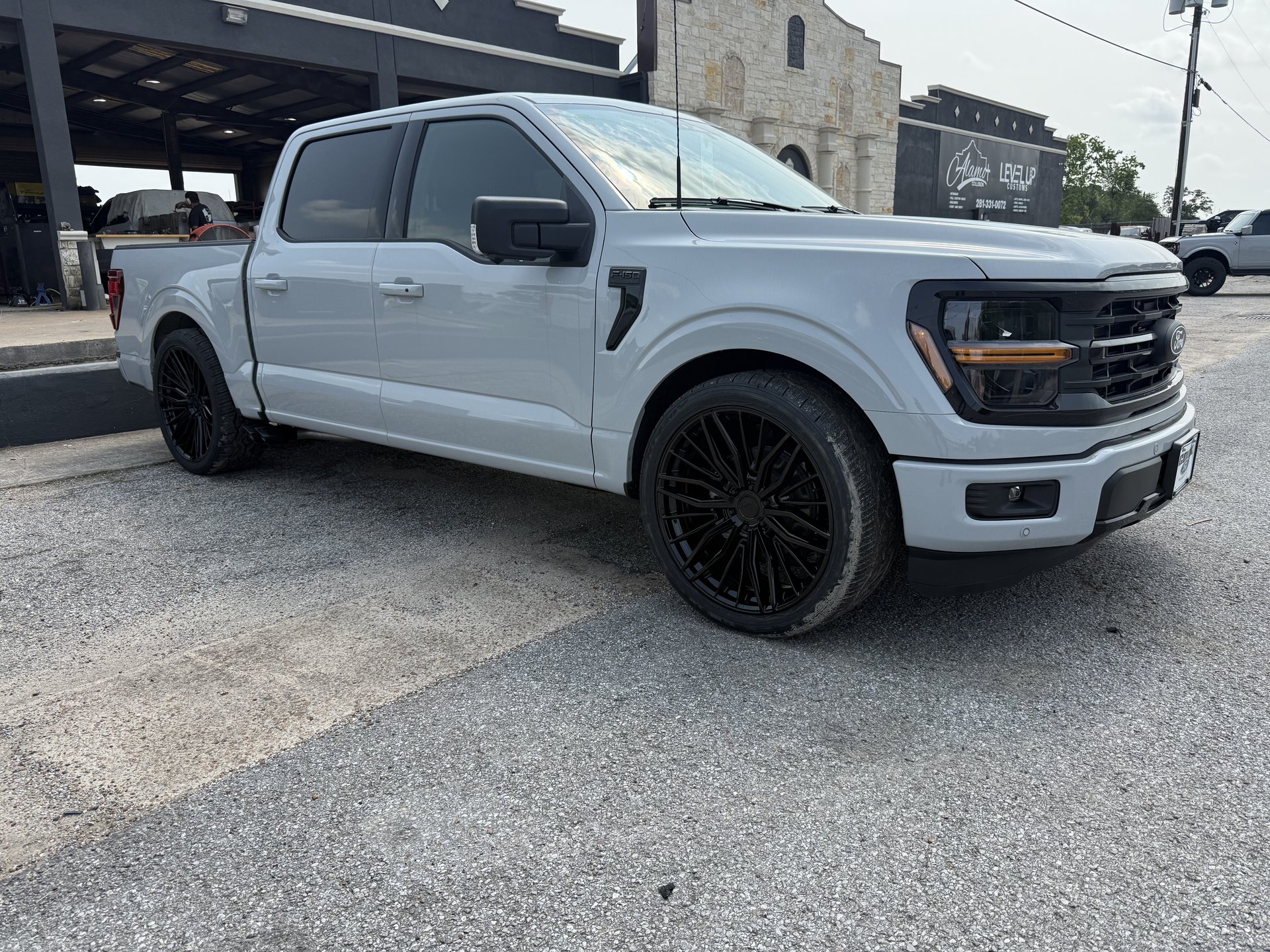 White Ford F-150 with stance lowering kit and blacked-out custom wheels, Level Up Customs, Alvin TX